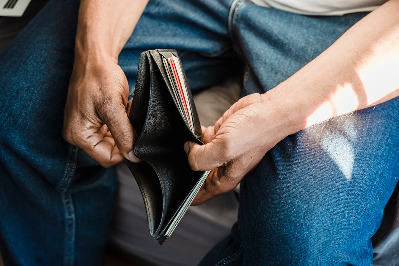 services-02 Close-up of a man holding an empty wallet, symbolizing financial crisis and hardship.